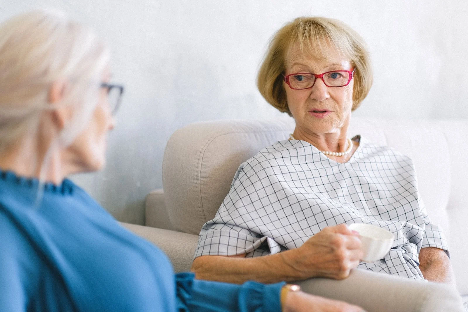 Two older women enjoying a conversation over tea.
