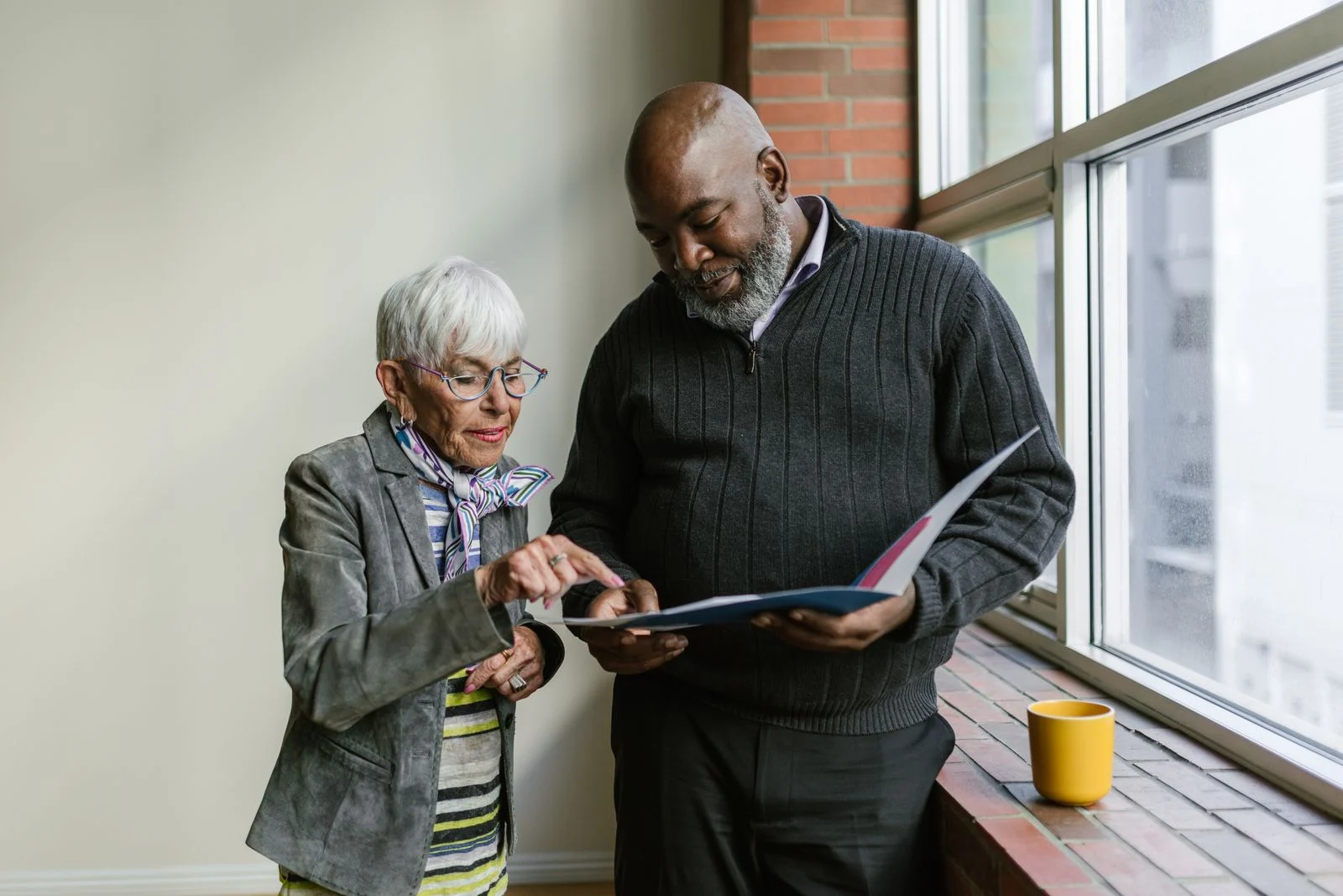 Two older adults reviewing a folder together.