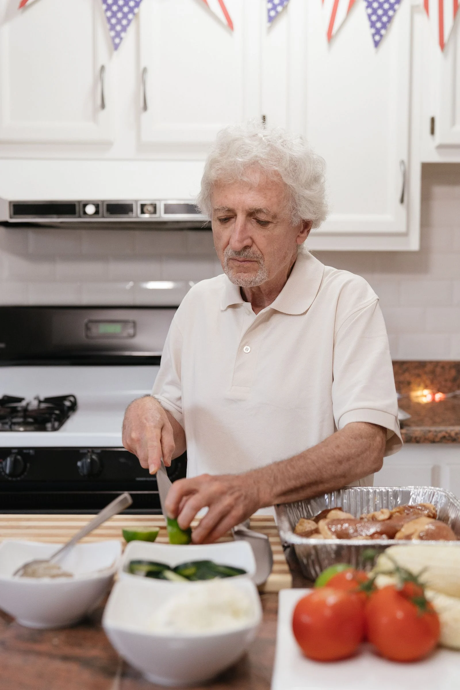 An older man preparing vegetables in a kitchen.