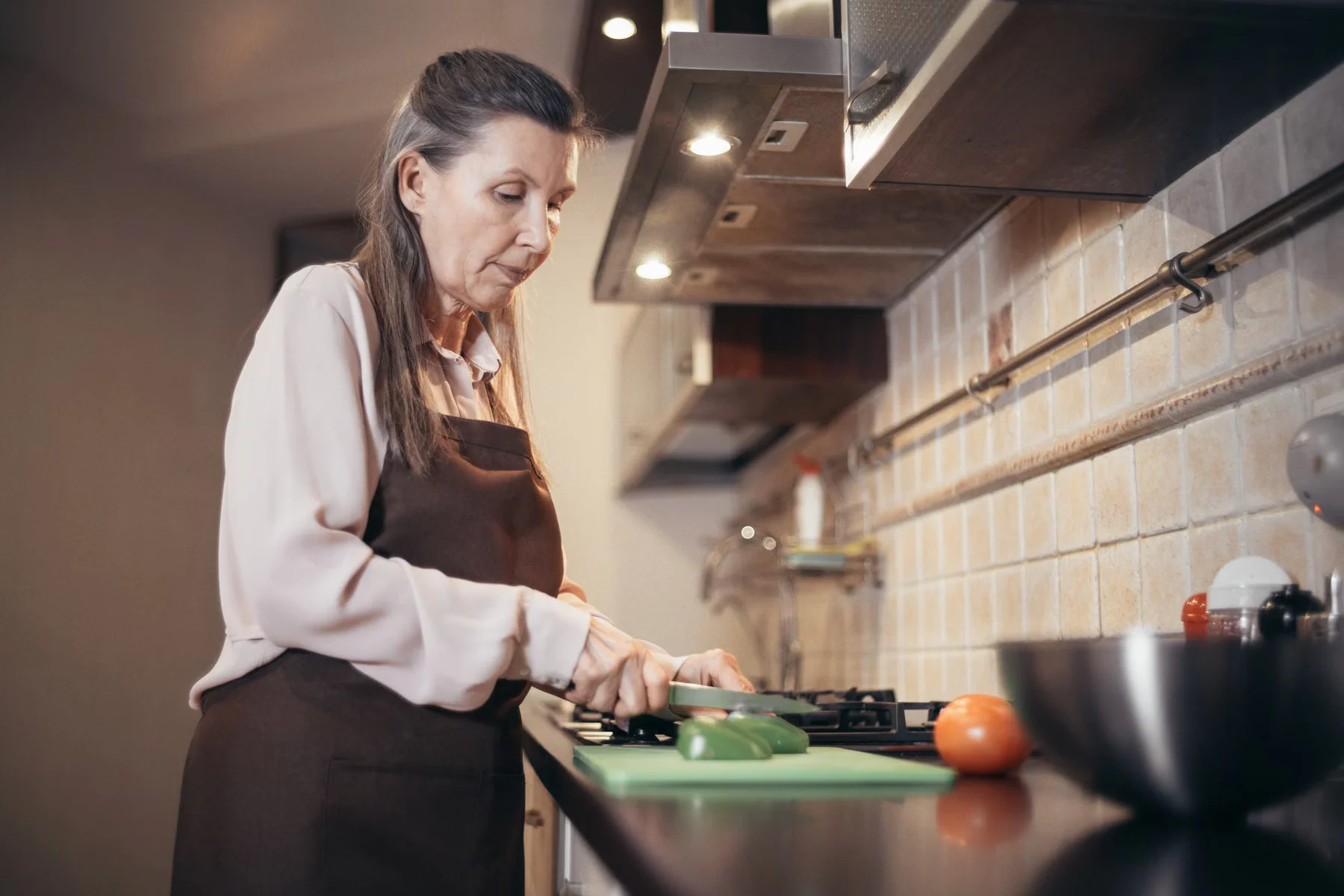 A woman preparing fresh vegetables in a kitchen.