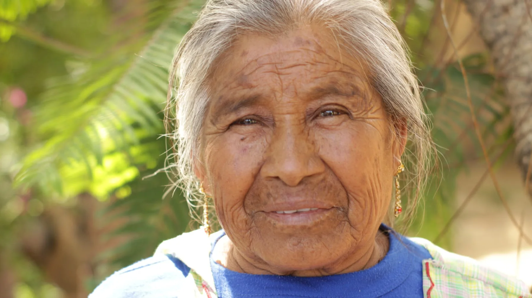 An older woman enjoying time outdoors in a garden.